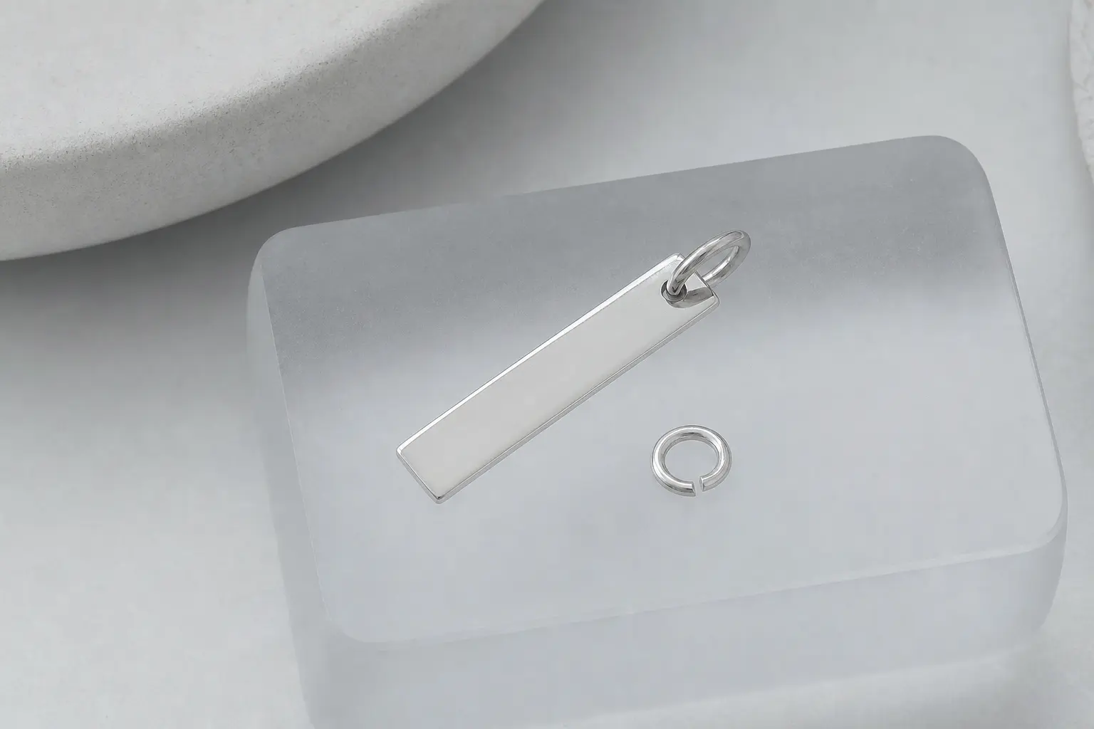 Minimal silver bar pendant on a rounded frosted acrylic block